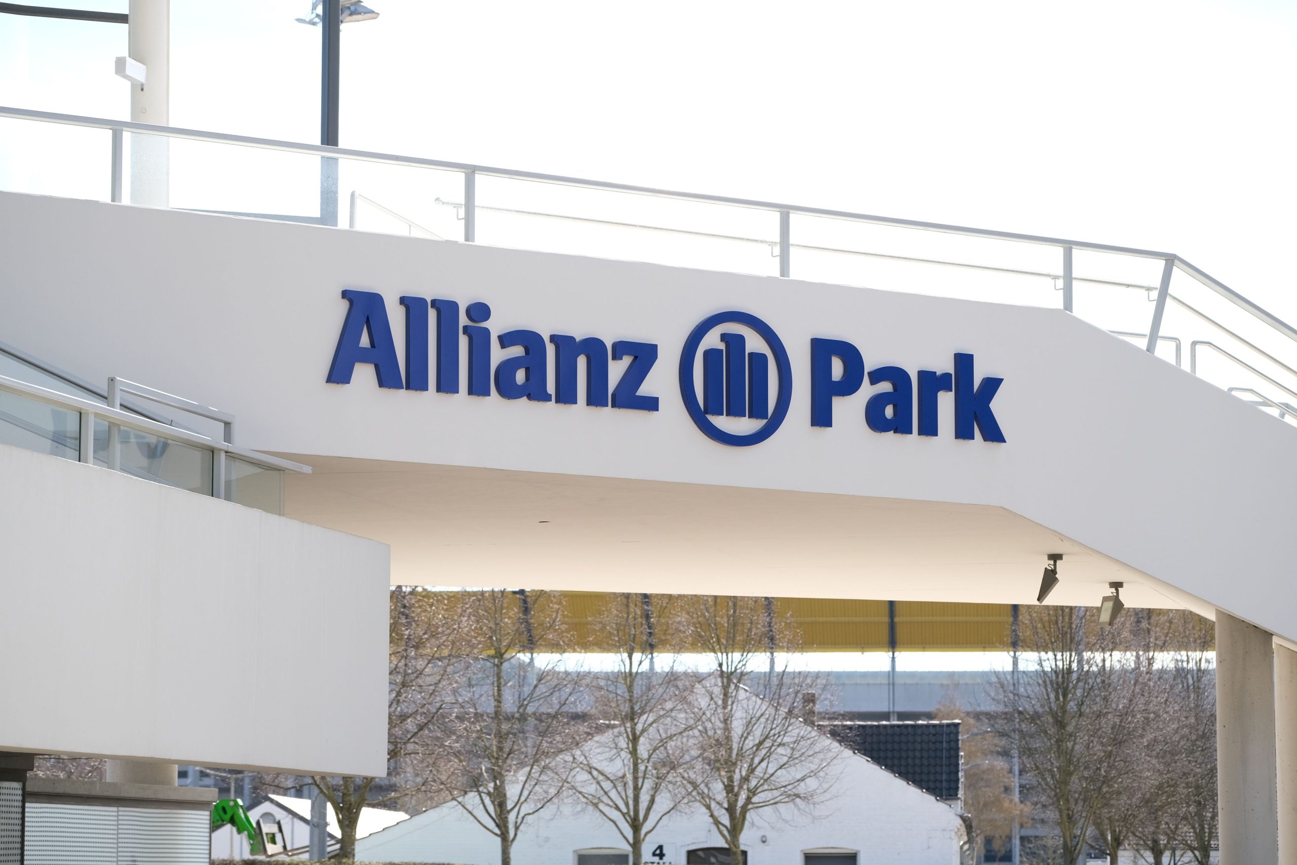 Nahaufnahme eines Gebäudeteils mit dem blauen Schriftzug „Allianz Park“ und dem Allianz-Logo an einer weißen Fassade.